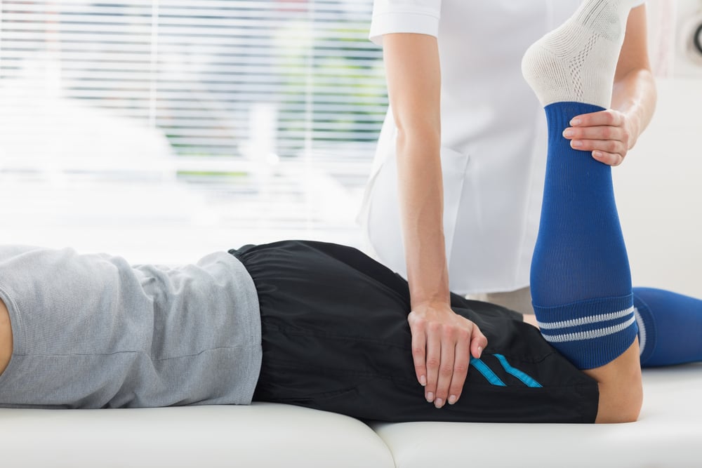 An athlete working with a physiotherapist to recover from fatigue while deloading