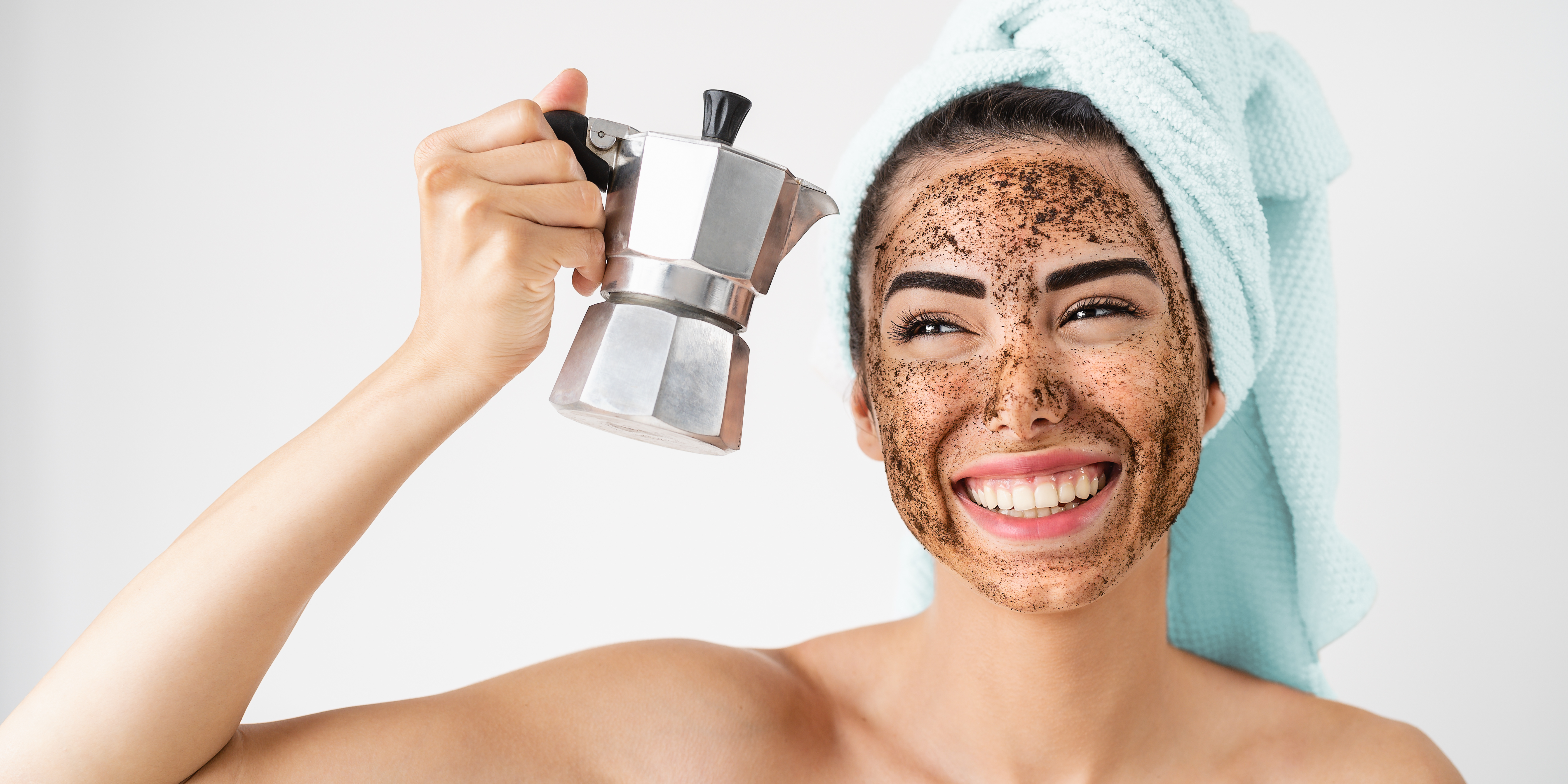 A smiling girl with coffee facial scrub and a French press in one hand.
