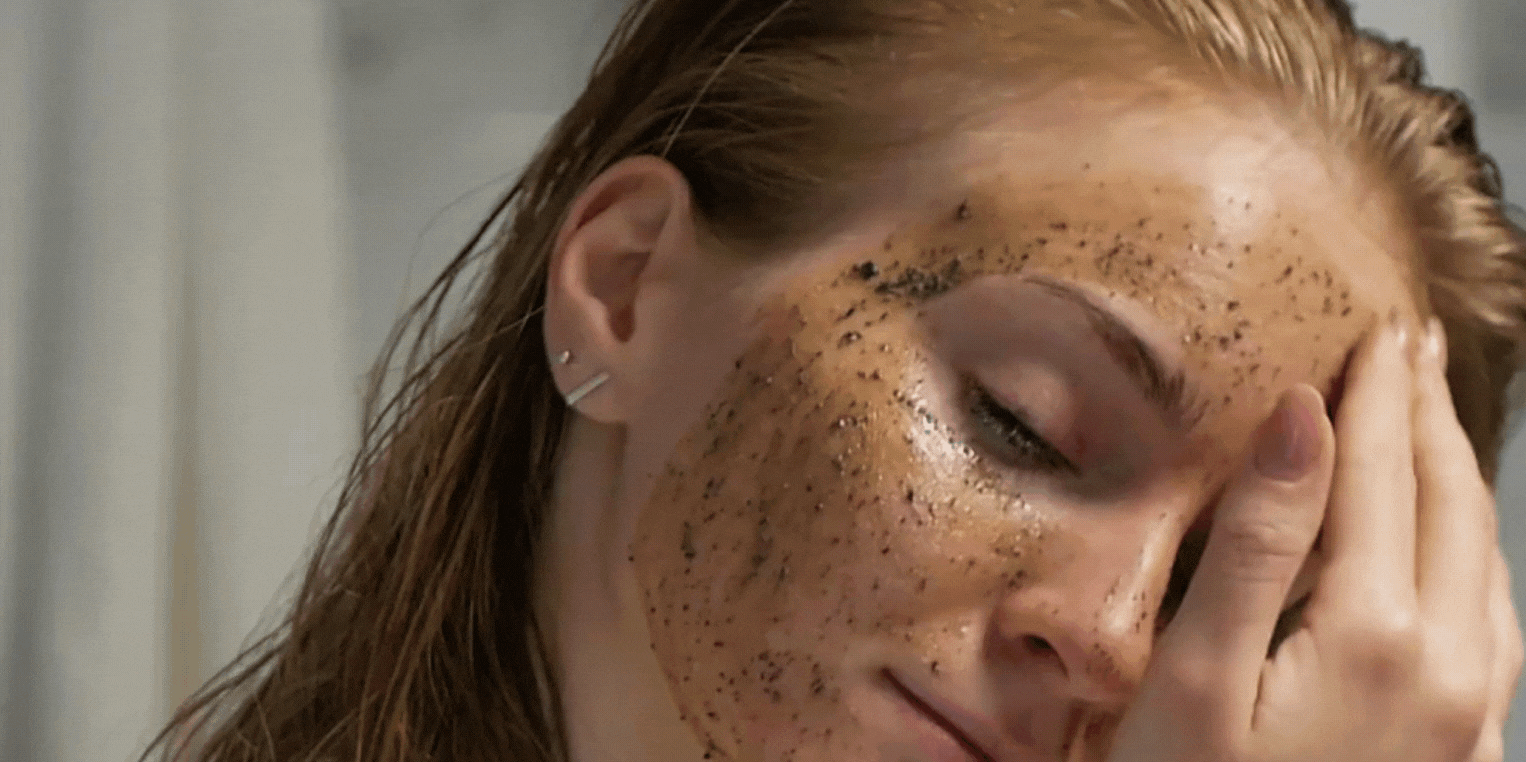 A girl applying facial coffee mask.